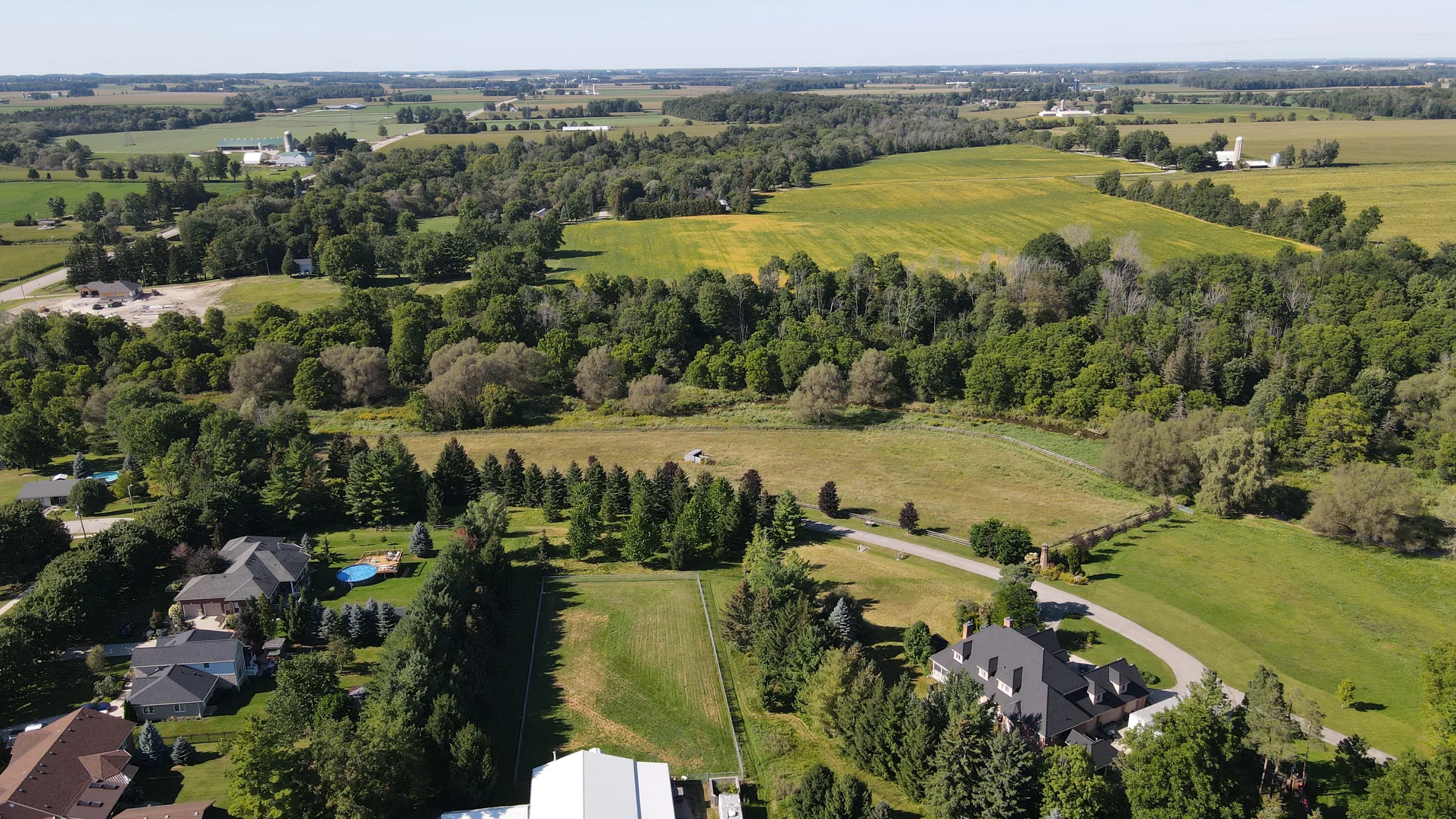 Aerial view of rolling farmland and woods around Embro