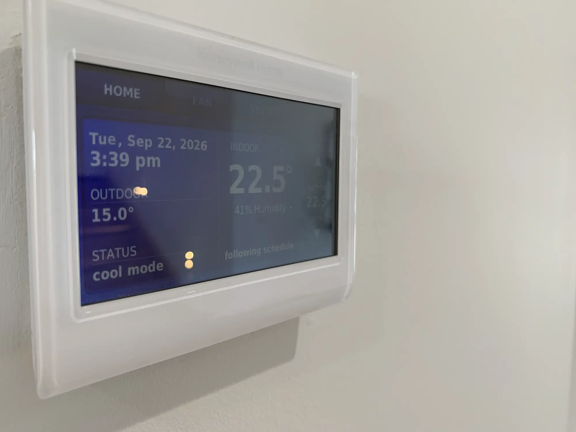 Programmable smart thermostat on a wall