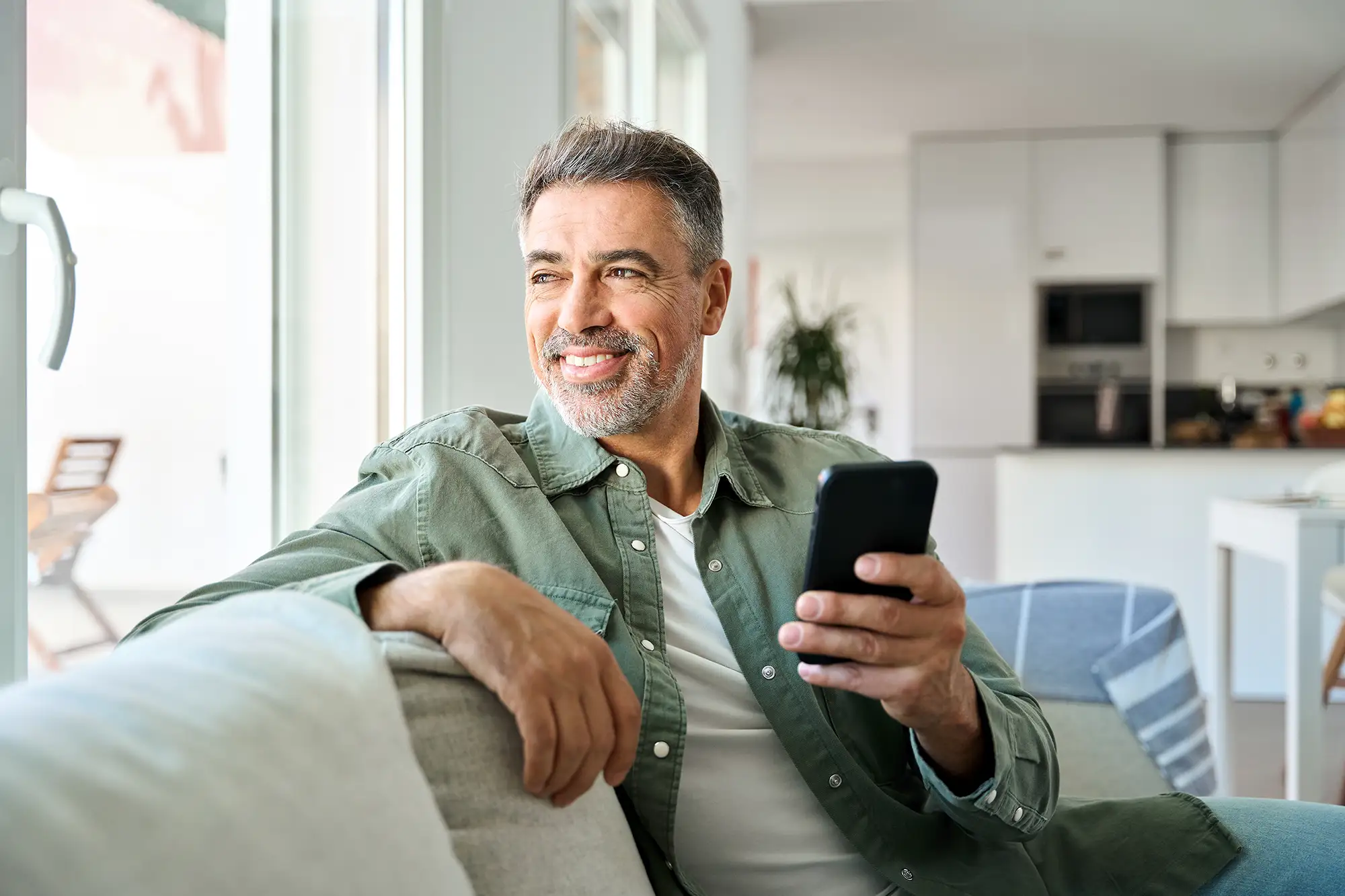 Man on the sofa holding his phone